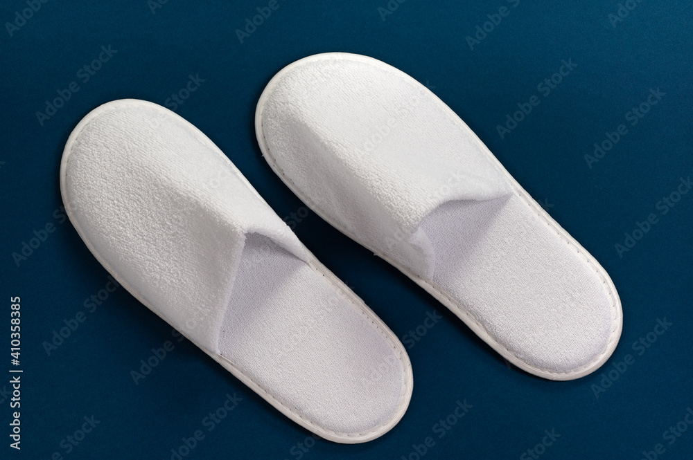 White slippers on a blue background. Slippers for guests. Slippers 素材庫