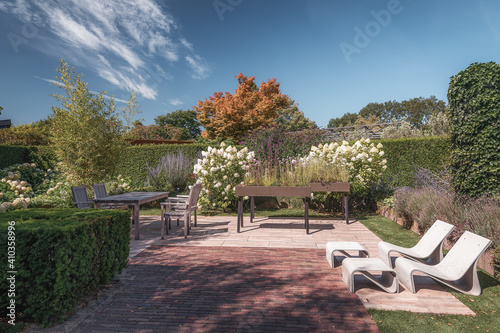 Two modern white sunbeds on a terrace in a garden somewhere in the Netherlands