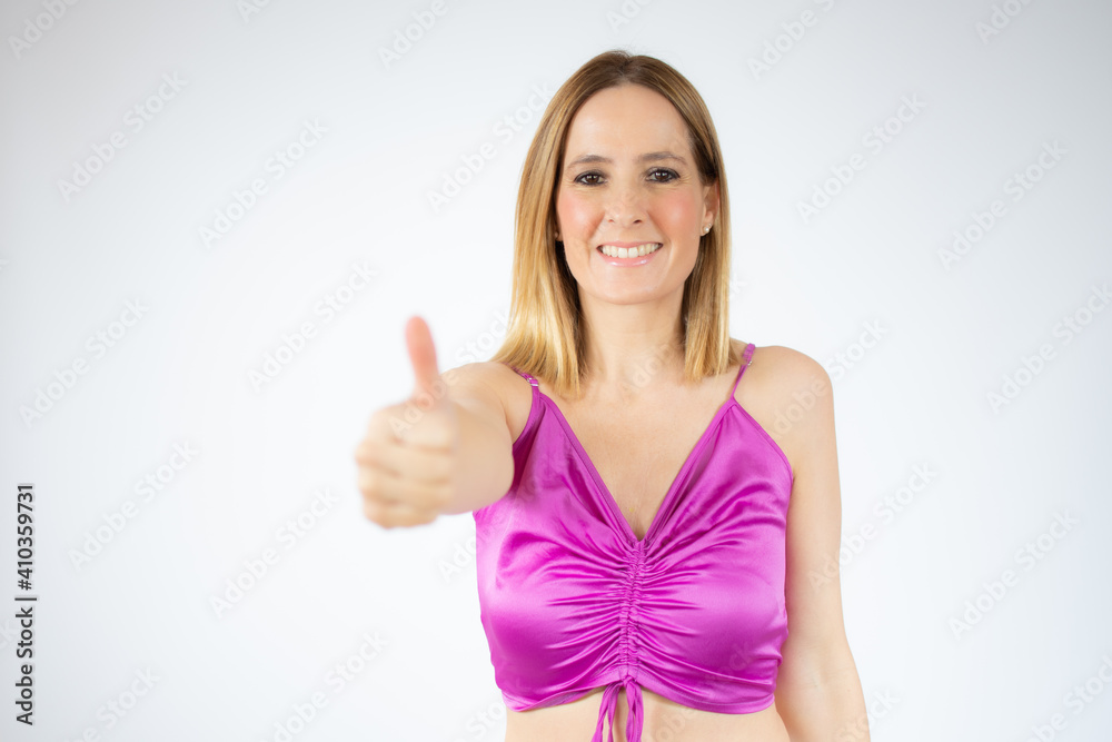 Smiling pretty young woman showing thumb up isolated over white background Smiling pretty young woman showing thumb up isolated over white background