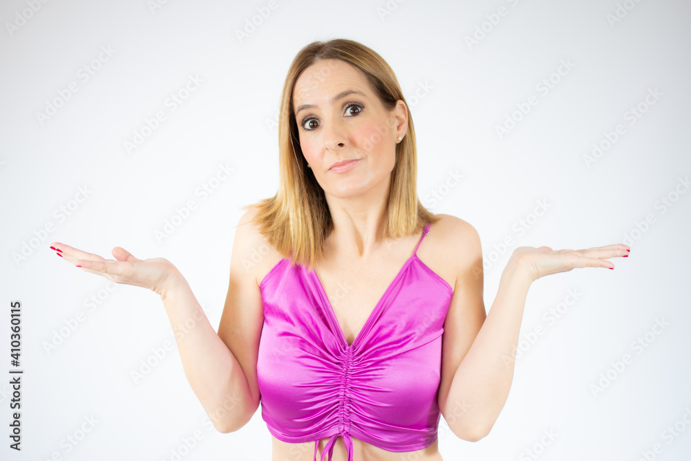 Young woman standing over white isolated background clueless and confused expression with arms and hands raised. Doubt concept. Young woman standing over white isolated background clueless and confused expression with arms and hands raised. Doubt concept.