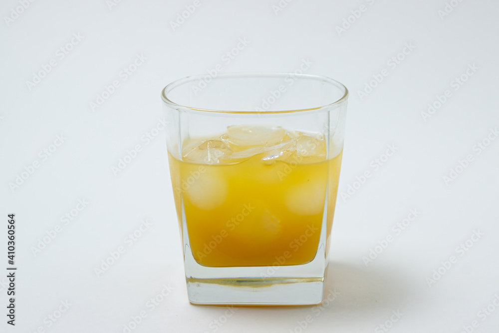 Juice with ice in a glass on a white background. Natural mango juice. Refreshing drink Juice with ice in a glass on a white background. Natural mango juice. Refreshing drink