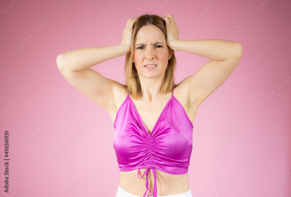Portrait of a young angry woman over pink background. Portrait of a young angry woman over pink background.