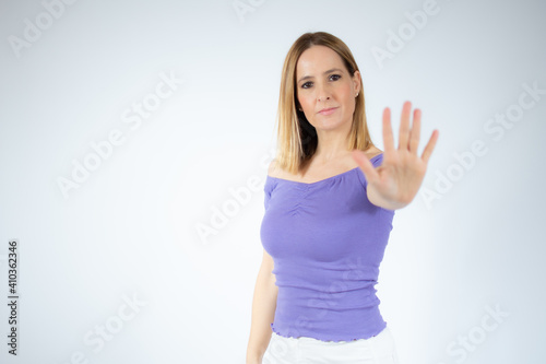 Portrait of a beautiful woman showing stop sign with palm isolated over white background