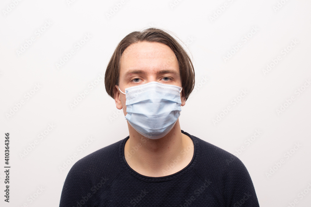 man with long hair with face mask on white background afraid of viruses man with long hair with face mask on white background afraid of viruses