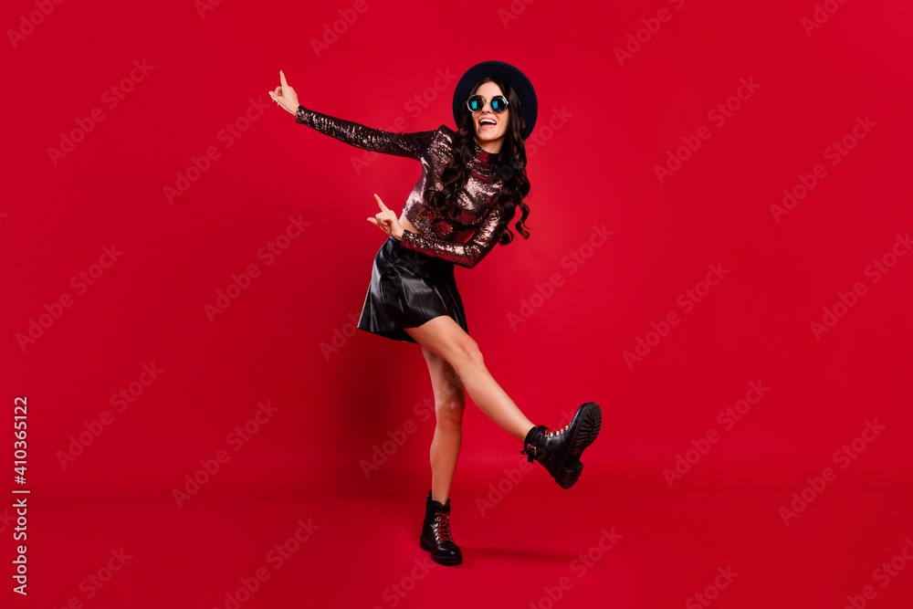 Full size portrait of crazy funny lady point fingers look empty space dance open mouth isolated on red color background