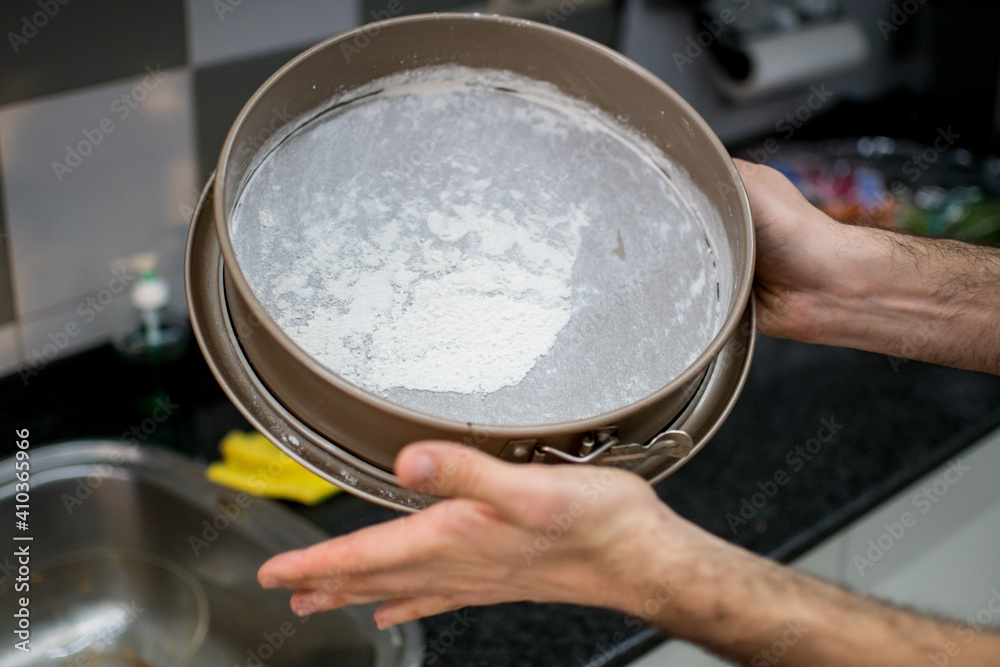 Mold being floured for a carrot cake Mold being floured for a carrot cake
