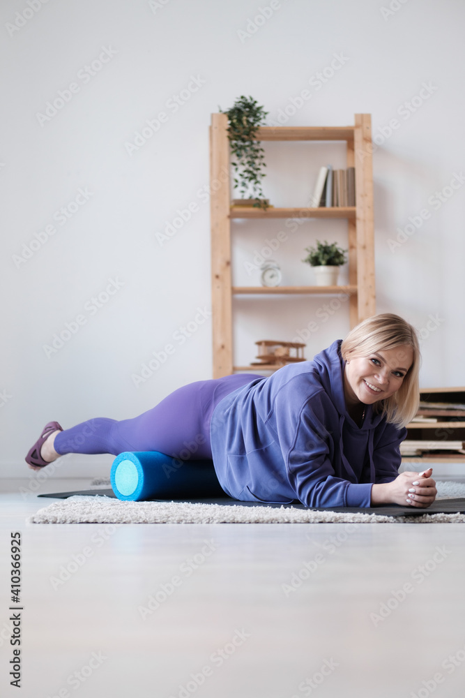 Young woman doing sport workout in room during quarantine. Stretching back on yoga mat. Lying on stomach and stretching up. Young woman doing sport workout in room during quarantine. Stretching back on yoga mat. Lying on stomach and stretching up.