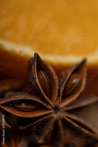 Half an orange and a star anise on a wooden table.