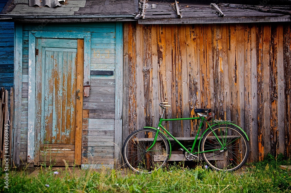 old bicycle in front of a wooden house