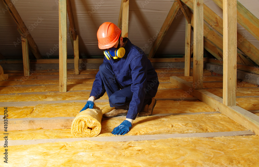 Worker insulate the attic with mineral wool - obrazy, fototapety, plakaty 
