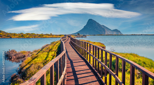 Fototapeta Naklejka Na Ścianę i Meble -  Beautiful summer scenery. Amazing summer view of Spiaggia di Porto Taverna beach with wooden footpath bridge. Wonderful morning scene of Sardinia island, Italy, Europe.