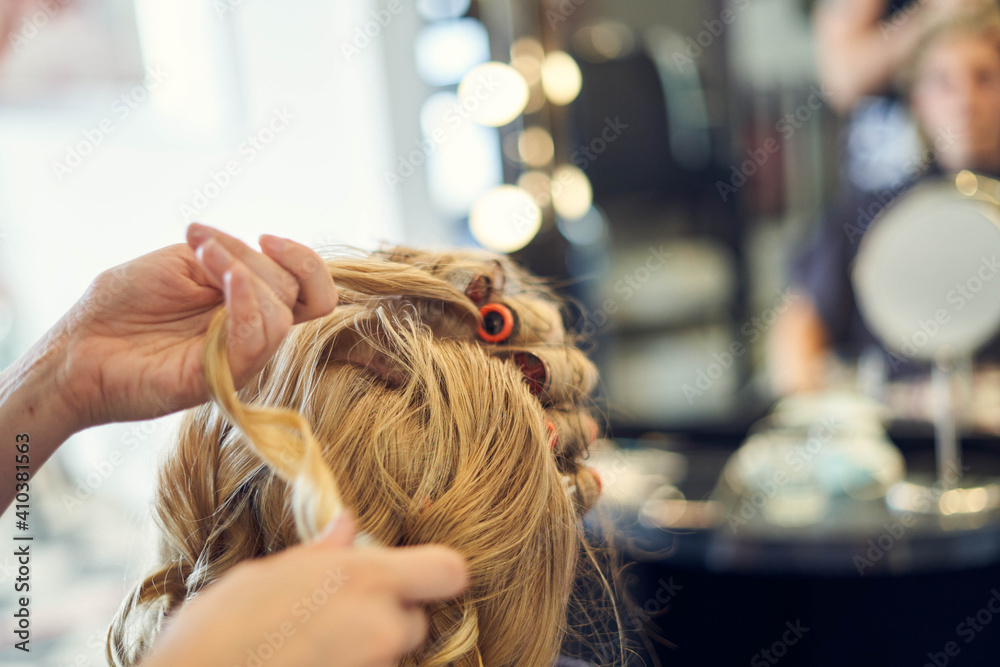 Fototapeta premium Blonde lockige Braut beim Friseur, getting ready
