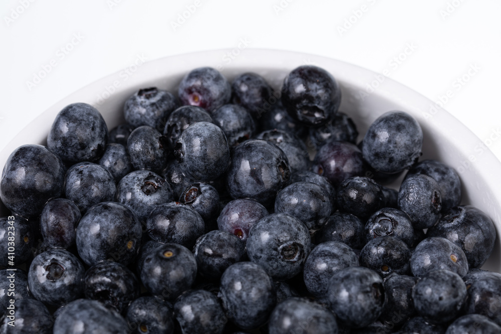 white bowl full with fresh blueberries on white background white bowl full with fresh blueberries on white background