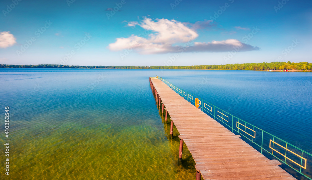 Beautiful summer scenery. Wooden pier on Pisochne Lake. Captivating morning scene of Shatsky National Park, Volyn region, Ukraine, Europe. Beauty of nature concept background. Beautiful summer scenery. Wooden pier on Pisochne Lake. Captivating morning scene of Shatsky National Park, Volyn region, Ukraine, Europe. Beauty of nature concept background.