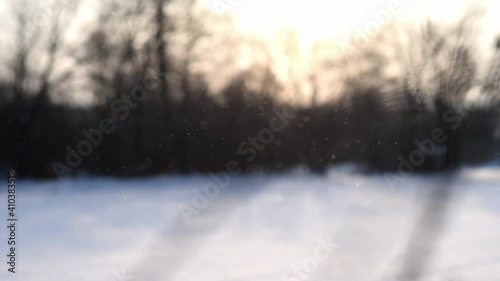 diamond dust with winter landscape in the background, ice crystals falling and sparkling in rising sun, rare meteorological phenomenon