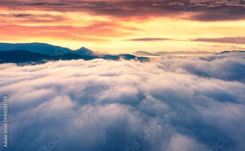 Foggy summer scenery. Flying above the clouds on drone. Captivating morning view of Carpathian mountains with Homiak mountain on background. Fabulous sunrise on Ukraine, Europe.