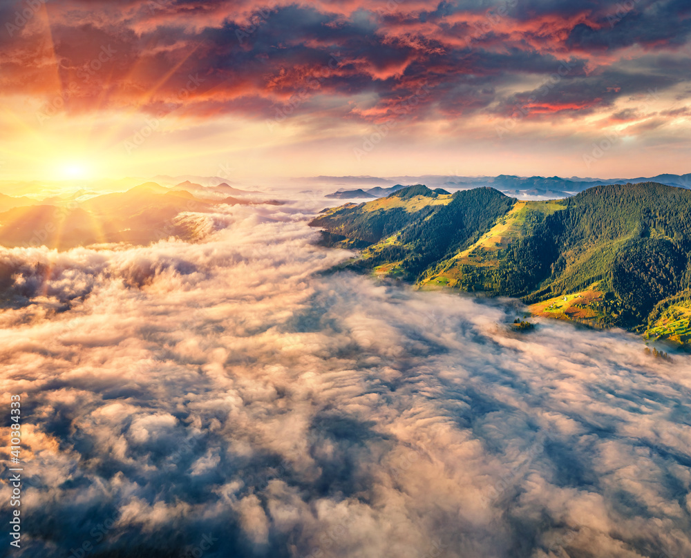 Aerial landscape photography. Sea of fog floving on the mountain valley. Dramatic summer scene of Snidavka village. Incredible morning view from flying drone of Carpathian mountains, Ukraine.