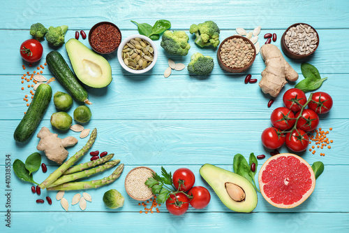 Fototapeta Naklejka Na Ścianę i Meble -  Frame of fresh vegetables, fruits and seeds on light blue wooden table, flat lay. Space for text