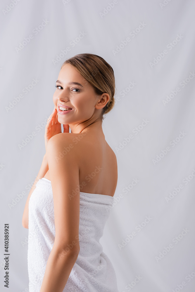 cheerful young woman wrapped in white towel smiling on white cheerful young woman wrapped in white towel smiling on white