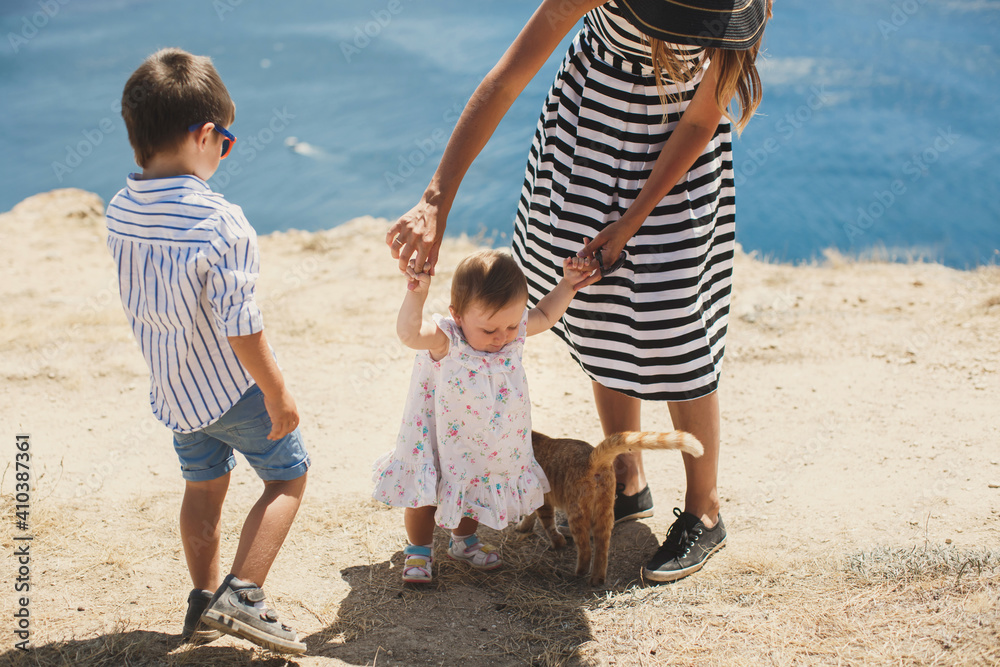 Happy family playing with a cat in nature. Happy family playing with a cat in nature.