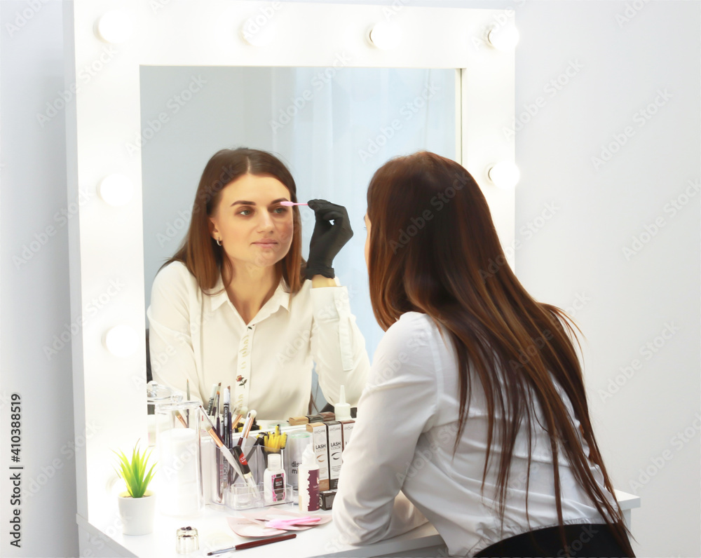 lashmaker, 30-year-old girl, European appearance, brunette, in the workplace, in a bright room, during the day. November 11, 2020, Russia, St. Petersburg, a girl applies makeup at the dressing table. lashmaker, 30-year-old girl, European appearance, brunette, in the workplace, in a bright room, during the day. November 11, 2020, Russia, St. Petersburg, a girl applies makeup at the dressing table.