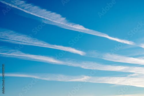 Background with blue sky and parallel airplane exhaust tracks. White chemtrails photo