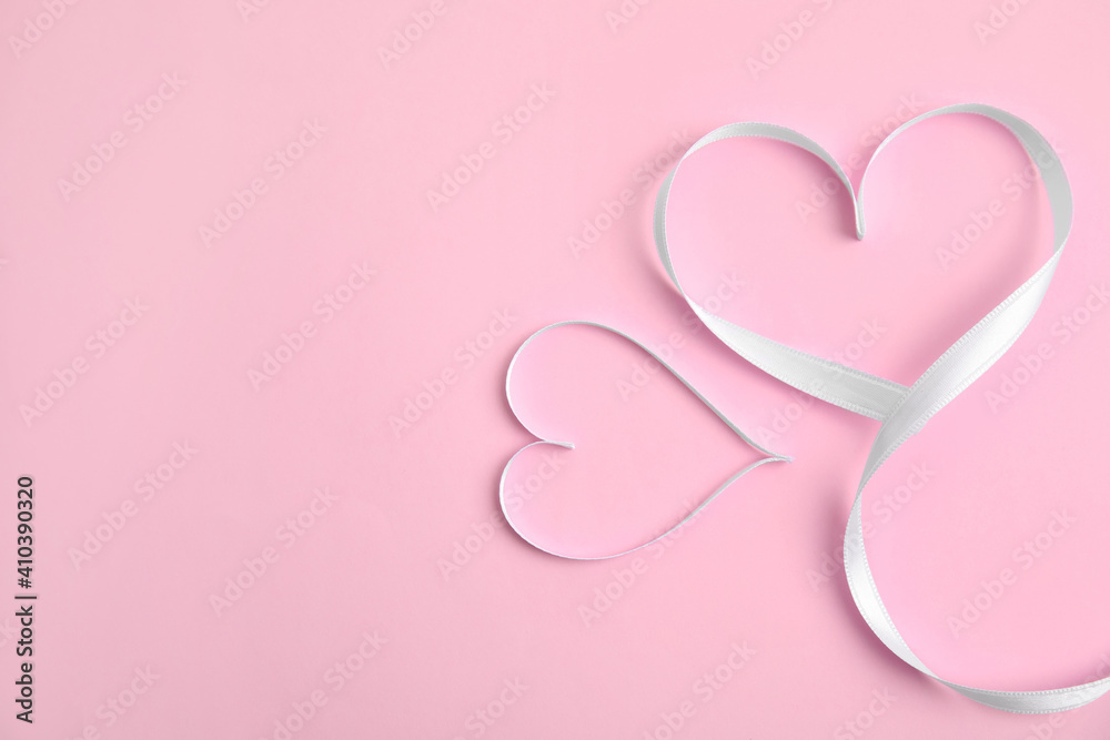 Hearts made of white ribbon on pink background, flat lay with space for text. Valentine's day celebration