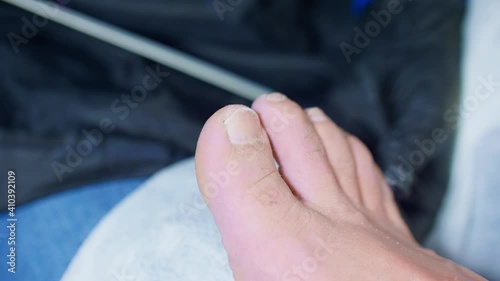 Manicurist files nails of toes on man's right leg. Close up view. photo