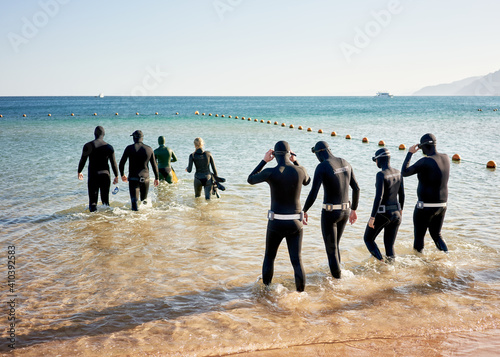 group of free divers on the beach, preparing to dive
