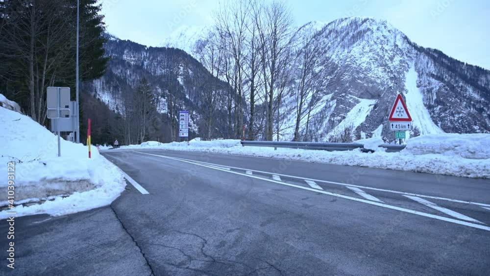 Countryside paved road in Alps mountains, Slovenia. Snow in winter season. Ljubelj saddle. Slovenia Austria border. Left pan, wide angle Countryside paved road in Alps mountains, Slovenia. Snow in winter season. Ljubelj saddle. Slovenia Austria border. Left pan, wide angle
