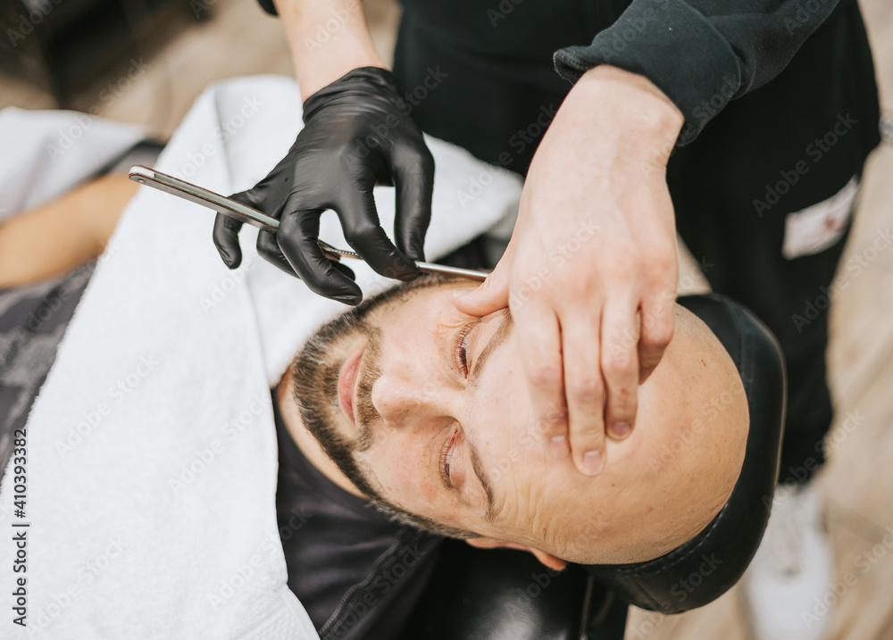 beard modeling in Barber shop, beard care for men, male beauty and care concept, shaving with a straight razor