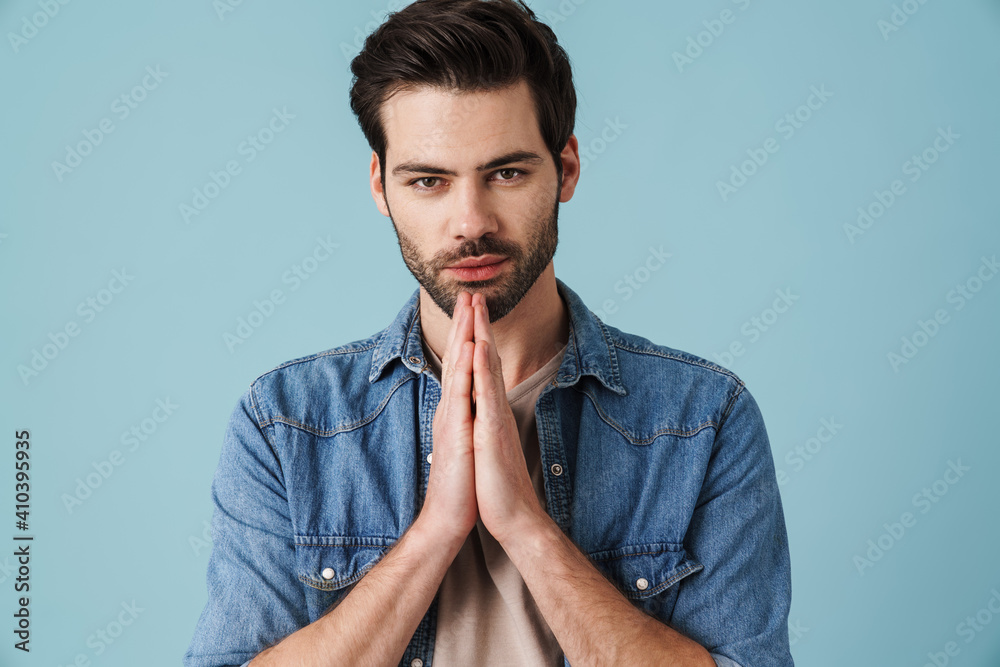 Young handsome unshaven man holding palms together Young handsome unshaven man holding palms together
