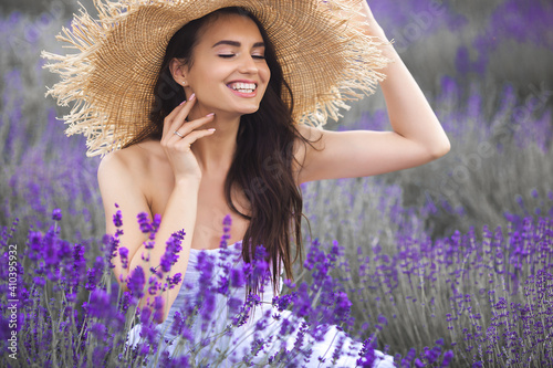 Beautiful young woman on lavender field. Aroma concept. Attractive young female outdoors.