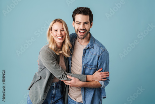 Obraz na plátně Young beautiful caucasian man and woman smiling and hugging at camera