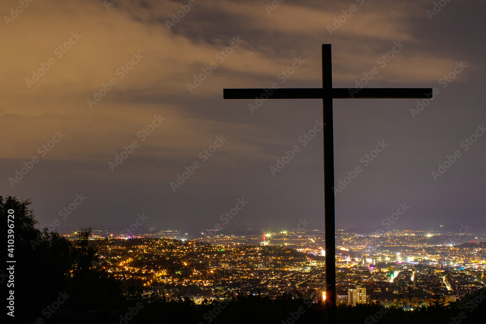 Birkenkopf Stuttgart mit Kreuz und Blick auf die Stadt mit Lichtern bei Sonnenuntergang