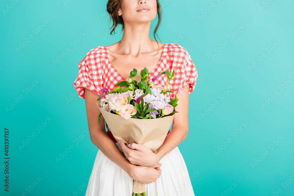 partial view of woman in stylish retro clothes holding bouquet isolated on turquoise partial view of woman in stylish retro clothes holding bouquet isolated on turquoise