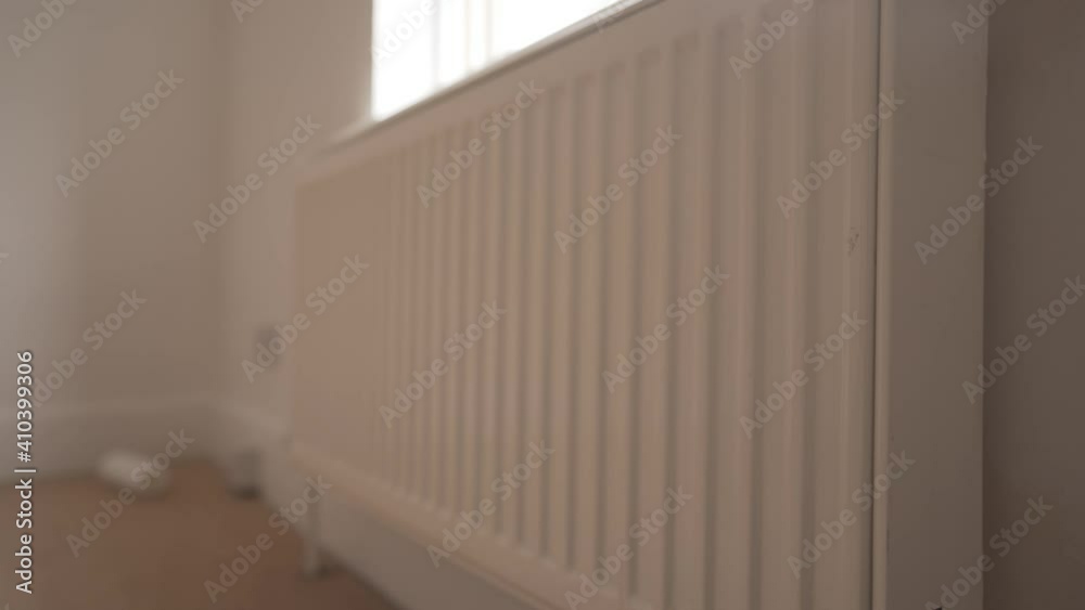 White metal heating radiator installed in wall of room in english house cambridge White metal heating radiator installed in wall of room in english house cambridge