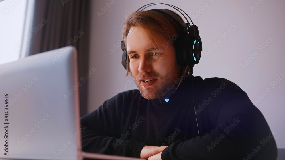 Remote work concept. Young man with headphones having online meeting on his laptop. High quality photo Remote work concept. Young man with headphones having online meeting on his laptop. High quality photo