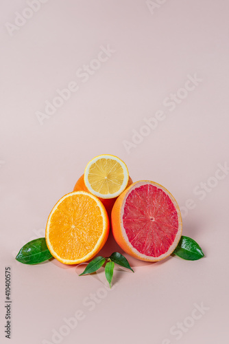 citrus fruits, grapefruits, mandarins, lemons, oranges, with green leaves lie on a light background.