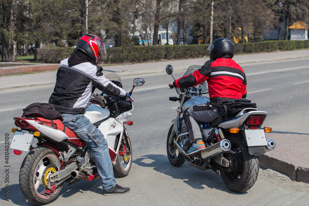 Two men on motorcycles on a city street
