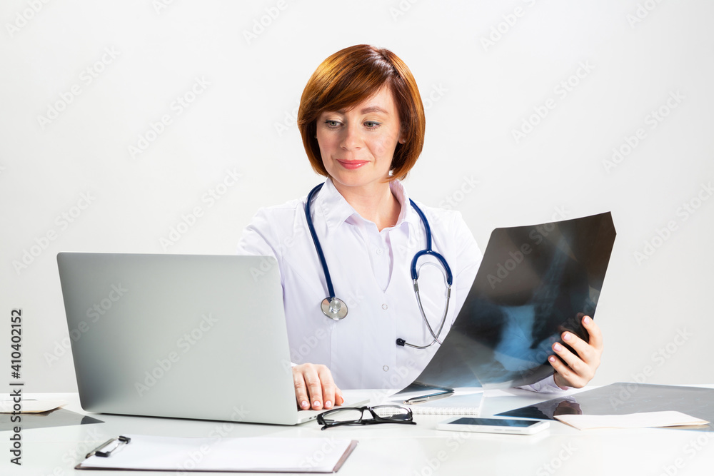Beautiful doctor looking at x-ray scan in office Beautiful doctor looking at x-ray scan in office