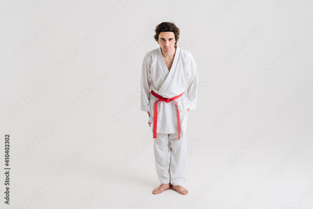 Young caucasian sportsman dressed in kimono practice in karate Young caucasian sportsman dressed in kimono practice in karate