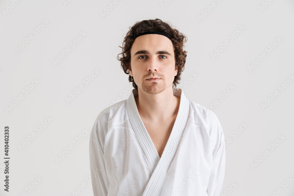Young caucasian sportsman dressed in kimono posing at camera
