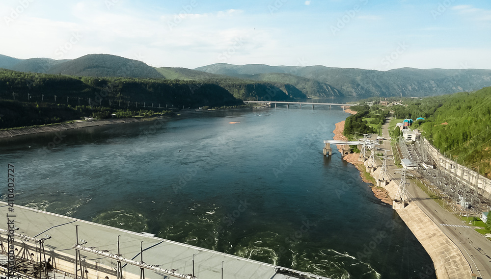 Bird's-eye view of  wide river. Beautiful mountain shores. Hydroelectric power station.