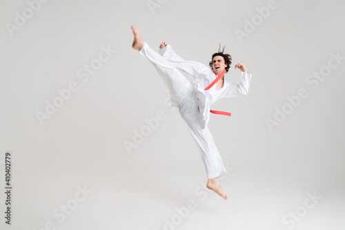 Fototapeta Naklejka Na Ścianę i Meble -  Young caucasian sportsman dressed in kimono practice in karate
