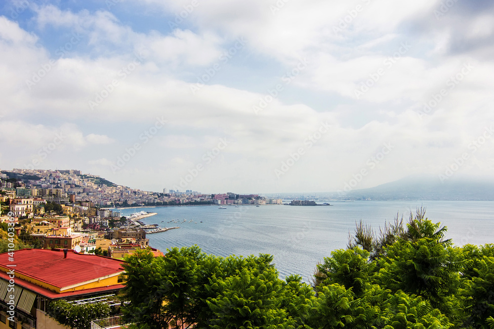 Aerial view on the embankment of Naples. Panoramic seascape of Napoli city with view of the port in the Gulf of Naples. Mount Vesuvius covered by fog. The province of Campania, Italy.