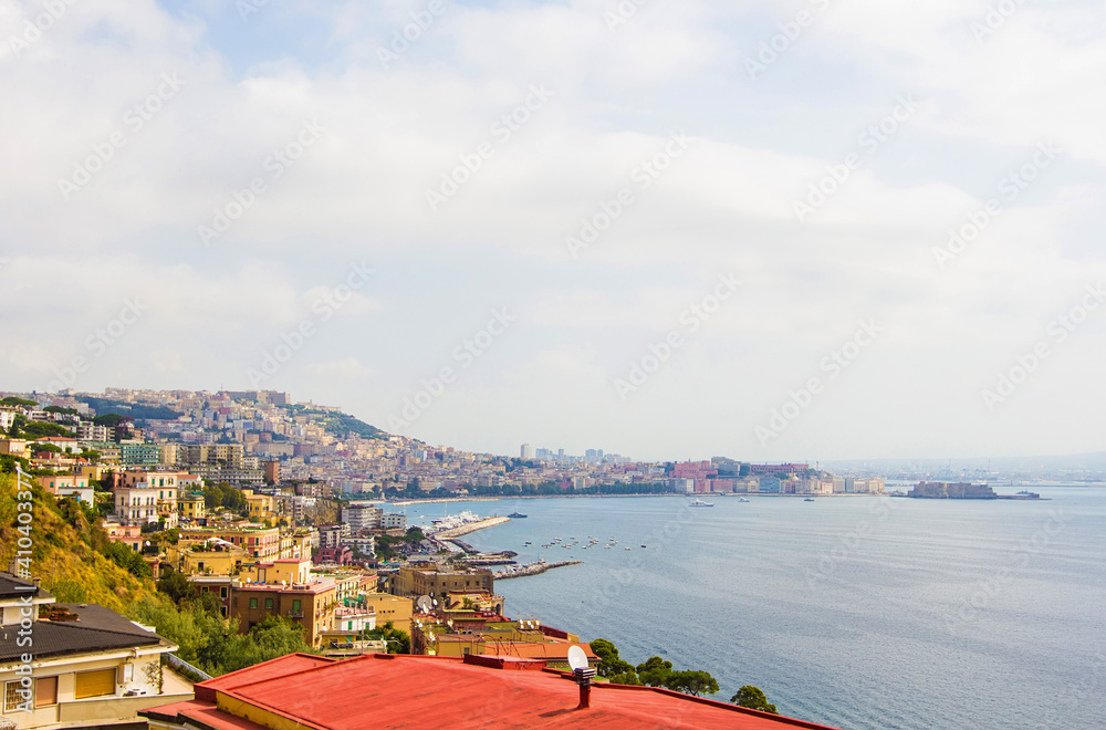 Top view on the embankment of Naples. Panoramic seascape of Napoli city with view of the port in the Gulf of Naples. Mount Vesuvius covered by fog. The province of Campania, Italy.