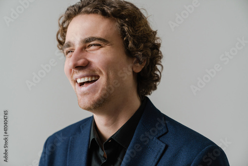 Joyful handsome man in jacket laughing and looking aside