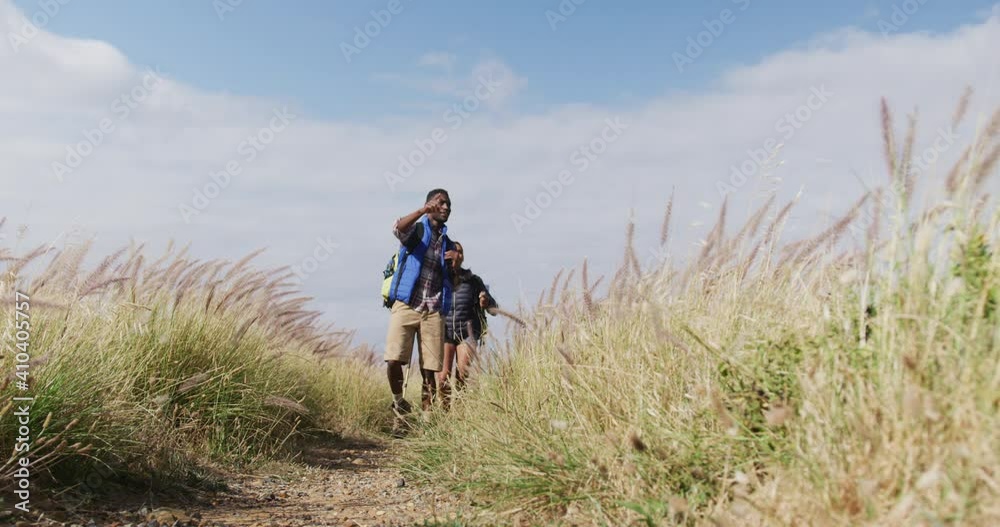 African american couple walking while trekking in the mountains African american couple walking while trekking in the mountains