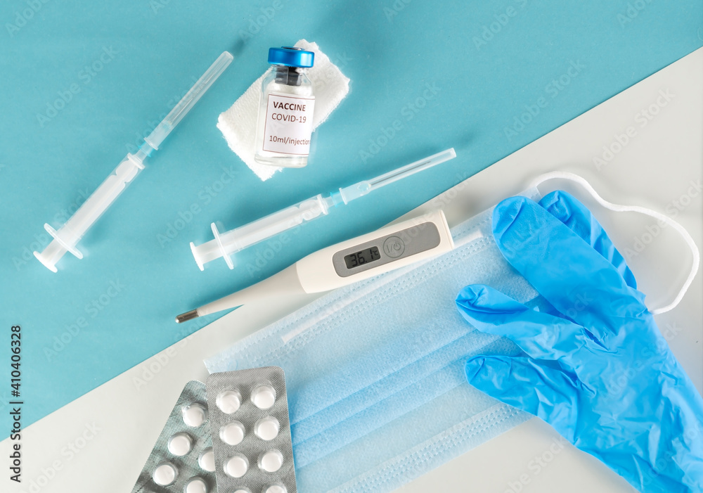 Vaccine against the Coronavirus and pandemic concept. Syringes for vaccination with vaccine vial against protective face masks, pills and gloves. Back to normal life. No quarantine, a new life begins. Vaccine against the Coronavirus and pandemic concept. Syringes for vaccination with vaccine vial against protective face masks, pills and gloves. Back to normal life. No quarantine, a new life begins.